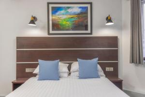 a bedroom with a large bed with blue pillows at Best Western Ebbw Vale in Ebbw Vale