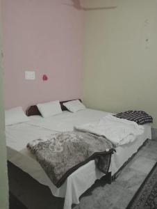 a bedroom with two beds with white sheets at Bhardwaj Home Stay in Mathura +50 photos