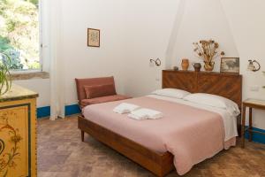 a bedroom with a large bed and a chair at Agriturismo Morani in Santa Severa