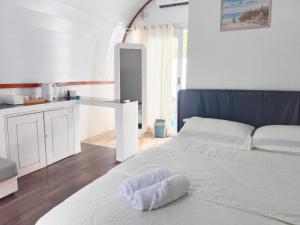 a white bed in a room with a kitchen at Mercy Cottage in Langgur +42 photos