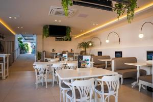 a restaurant with white tables and white chairs at Kastro Beach Apartments in Malia