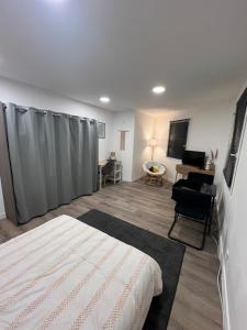 a bedroom with a bed and a living room at Grand Apt tout équipé et confortable in Aytré