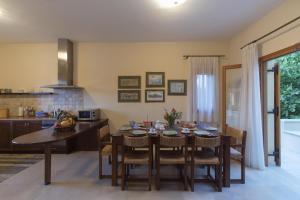 a kitchen and dining room with a table and chairs at Villa Manolia in Prinés