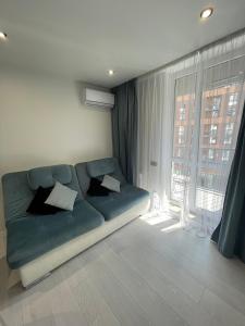 a living room with a couch and a large window at Апартаменти в новобудові Авалон Зелена in Lviv
