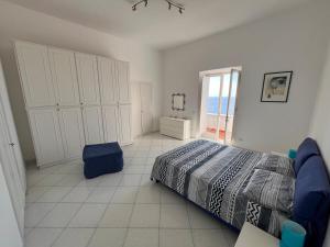a white bedroom with a bed and a window at Apartment in Villa Argentina in Capri