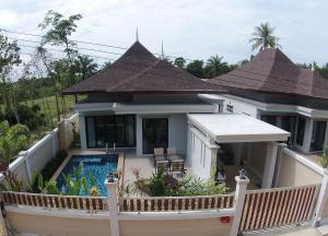 a house with a swimming pool in front of it at Baan Ping Tara Tropical Pool Villa and Scooter in Ban Khlong Son