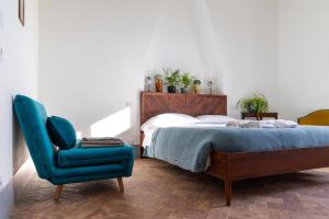 a bedroom with a bed and a blue chair at Agriturismo Morani in Santa Severa