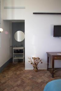 a living room with a table and a mirror at Agriturismo Morani in Santa Severa