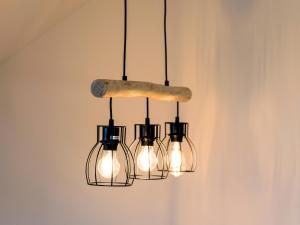 un lampadario a quattro luci appeso a una parete di Ferienwohnung Aufhausen - die Sternengucker-Wohnung im 5-Seen-Land a Berg am Starnberger See