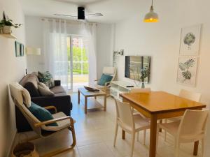 a living room with a table and a couch at Jardines de Veneciola by Alina365 in La Manga del Mar Menor