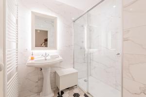 ein weißes Badezimmer mit Waschbecken und Dusche in der Unterkunft Maison Koch · Maison bourgeoise - 240 m2 in Straßburg + 13 Fotos