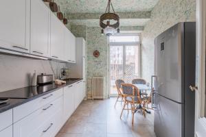 eine Küche mit weißen Schränken und einem Tisch mit Stühlen in der Unterkunft Maison Koch · Maison bourgeoise - 240 m2 in Straßburg