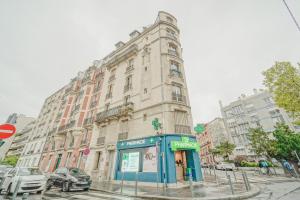 a large building on a city street with a phone booth at Charming studio near Paris in Saint-Ouen