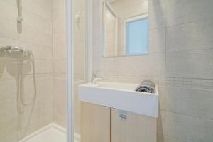 a white bathroom with a sink and a shower at Charming studio near Paris in Saint-Ouen