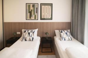 two beds in a room with two night stands at Boutique Apartment - Široki Brijeg in Široki Brijeg