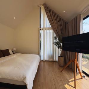 um quarto com uma cama e uma TV de tela plana em The Nature House Botique Resort & Cafe - Ban Mung em Ban Mung mais 25 fotografias
