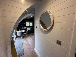 a hallway with a round mirror on a wall at Serenity Lodge in Donisthorpe
