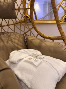 a white towel sitting on a couch with a mirror at Dimora Palermo with private pool in Palermo