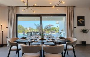 a dining room with a table and chairs and a large window at Villa IVaLA in Pula