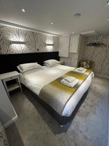 a bedroom with a large bed with towels on it at Garden Mews - 2 double bedrooms - Harrogate Holiday Apartments in Harrogate