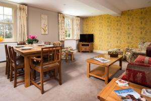 ein Wohnzimmer mit Tisch und Couch in der Unterkunft Dairy Cottage in Knapton