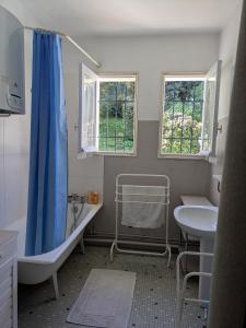 a bathroom with a blue shower curtain and a sink at Villa centre ville SOULAC sur Mer in Soulac-sur-Mer +6 photos
