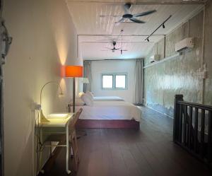 ein Schlafzimmer mit Bett, Schreibtisch und Fenster in der Unterkunft LEJU 79 樂居 A Heritage Getaway in the Heart of Melaka in Malakka