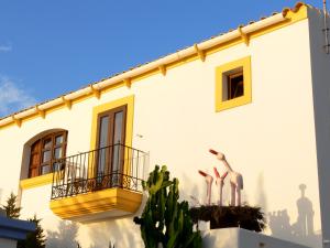 a white building with a balcony with flamingos on it at Hostal la Savina in La Savina