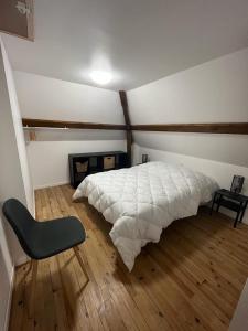 ベス・エ・サンタナステーズにあるGrand Gîte le Skieur à Besseのベッドルーム1室(ベッド1台、椅子付)