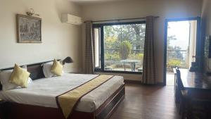 Un dormitorio con una cama y una ventana grande. en 8fold-Pinecrest By LaRiSa, Bhimtal, en Bhimtal