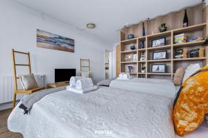 a bedroom with two beds and a tv at Ferienwohnung Sydvind 8408 Marina Wendtorf in Wendtorf