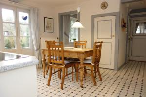 a kitchen with a wooden table and chairs in a room at Ferienhaus Süderende 50 in Süderende