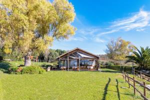 a gazebo in a park with a tree at Agriturismo Morani in Santa Severa