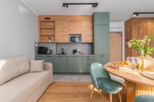 a living room with a couch and a table at APARTAMENTY MIERZEJA - STEGNA PARK II, MEDIUM, 500 m od plaży, Bezpłatny Meleks in Stegna