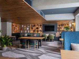 a restaurant with tables and chairs and a flat screen tv at Novotel Nara in Nara