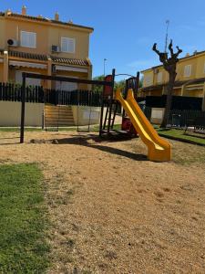 a playground with a slide in front of a building at Casa coqueta con jardin in La Redondela