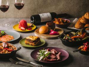 a table topped with plates of food and wine glasses at Grand Mercure Ise-shima Resort & Spa in Shima
