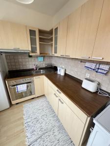 a kitchen with wooden cabinets and a counter top at Apartmán Športovcov in Dolný Kubín