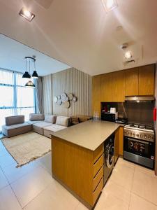 una cucina e un soggiorno con divano di 1BR Desert Modernism by Blue Cloud Holidays a Sharjah Intl