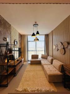 un soggiorno con un divano e una televisione di 1BR Desert Modernism by Blue Cloud Holidays a Sharjah Intl