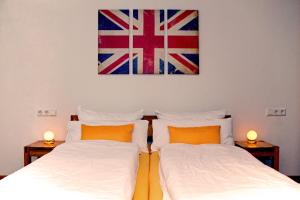two beds in a room with a flag on the wall at Pension Neulen in Rust