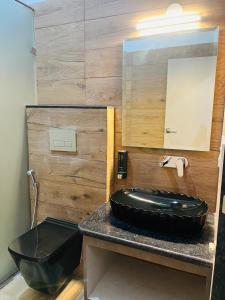 a bathroom with a black sink and a mirror at Praleen Villa in Udaipur +26 photos