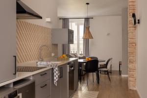 a kitchen with a counter and a table with chairs at Apartamentos Líbere Valencia Jardín Botánico in Valencia