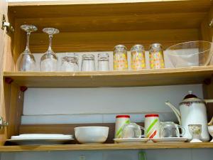 a wooden shelf with glass items on it at Softlife Home Classic Studio 2 in Mombasa