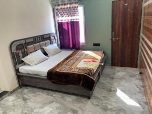 a bedroom with a bed with a purple curtain at Yuvraj Guest house in Khātu
