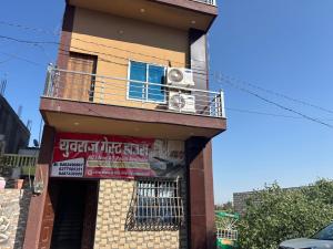 a building with a balcony and a sign on it at Yuvraj Guest house in Khātu