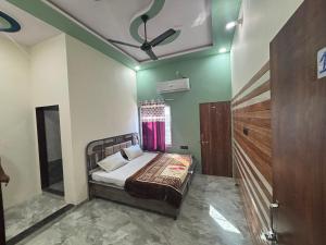 a bedroom with a bed with green walls and a ceiling at Yuvraj Guest house in Khātu