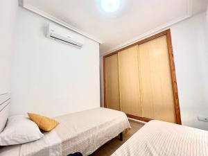a bedroom with two beds and a closet at Adosado Mar Serena in San Juan de los Terreros