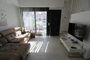 een woonkamer met een bank en een televisie bij Fabulous Villa with private pool & large roof solarium in Villamartin