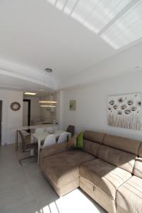 een woonkamer met een bank en een tafel bij Fabulous Villa with private pool & large roof solarium in Villamartin